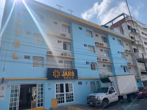 um camião estacionado em frente a um edifício azul em Hotel Jar8 Boca -Cerca WTC y plazas comerciales- em Veracruz