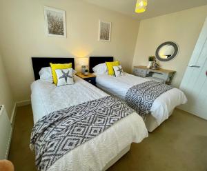 two beds sitting next to each other in a room at Luxurious Beach House with spectacular sea views in Felixstowe