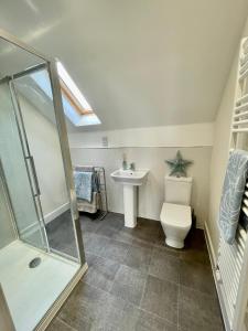 a bathroom with a shower and a toilet and a sink at Luxurious Beach House with spectacular sea views in Felixstowe