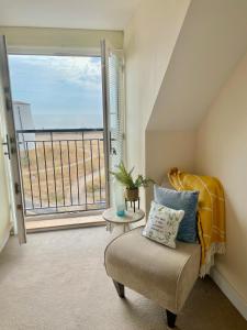Zimmer mit einem Stuhl und Meerblick in der Unterkunft Luxurious Beach House with spectacular sea views in Felixstowe