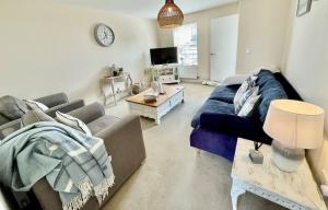 a living room with a blue couch and a table at Luxurious Beach House with spectacular sea views in Felixstowe