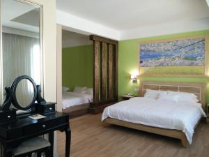 a bedroom with a bed and a mirror and a desk at Hotel Balik Pulau in Melaka