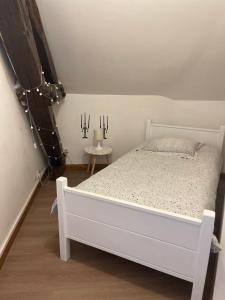 een slaapkamer met een wit bed en een bijzettafel bij Troisieme du nom in Nevers
