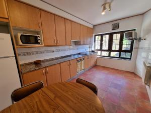 a large kitchen with a table and a microwave at Casa Satya 