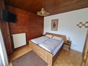 een slaapkamer met een bed en een flatscreen-tv bij Apartmenthaus Almwiese Flattnitz in Flattnitz