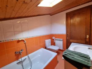 a bathroom with a tub and a toilet and a sink at Casa Satya 