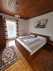 a bedroom with a large bed and a wooden ceiling at Apartmenthaus Almwiese Flattnitz in Flattnitz