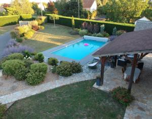 une piscine dans un jardin avec un kiosque dans l'établissement La Palentine, à Châteaumeillant