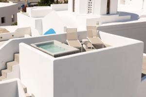a view of a white building with chairs and a pool at Cydonia Caves in Megalochori