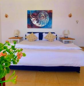 1 dormitorio con 1 cama blanca grande y 2 mesas en Sunrise Resort Jebel Shams منتجع شروق الشمس جبل شمس, 