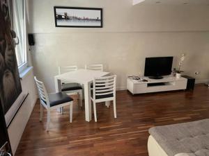 uma sala de estar com uma mesa e cadeiras e uma televisão em CITY CENTER DUPLEX em Belgrado