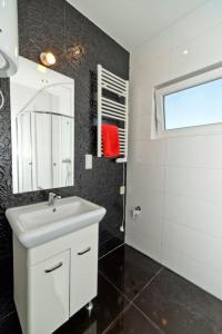 Un baño con un lavabo blanco y un espejo. en Apartamenty DandE, en Władysławowo