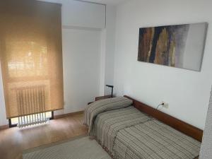 Apartamento Centrico y Tranquilo El Rinconcito في أورينس: غرفة نوم بسريرين ونافذة