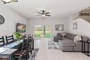 a living room with a ceiling fan and a couch and a table at Newly Remodeled 4BD/4BA Townhouse-Regal Palms Resort Near Disney in Davenport