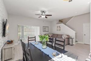 uma sala de estar com uma mesa e um sofá em Newly Remodeled 4BD/4BA Townhouse-Regal Palms Resort Near Disney em Davenport