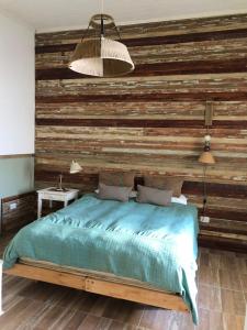Un dormitorio con una pared de madera y una cama en Azul en Lavalle 3 en Azul