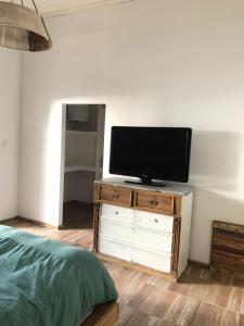 1 dormitorio con TV de pantalla plana en una cómoda de madera en Azul en Lavalle 3 en Azul