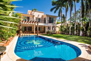 a swimming pool in front of a house at Casa Jaguar in Puerto Aventuras
