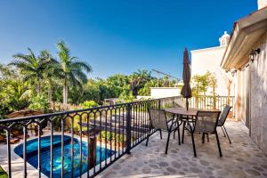 a balcony with a table and chairs and a swimming pool at Casa Jaguar in Puerto Aventuras
