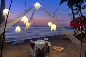 a dinner table on the beach at night at The Chandi Boutique Resort & Spa in Senggigi