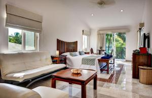 a living room with a couch and a bed and a table at Casa Jaguar in Puerto Aventuras