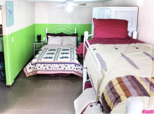 Texcoco de MoraにあるHermoso Departamento en Texcoco centro con wifi cocinaの緑と白の壁の客室内のベッド2台