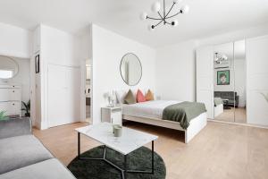 a white bedroom with a bed and a living room at Luxury Two Bedroom Apartment in Marylebone - Central London in London