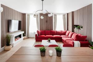 a living room with a red couch and a tv at Luxury Two Bedroom Apartment in Marylebone - Central London in London