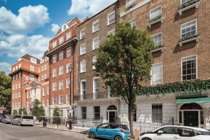 a brick building with cars parked in front of it at Luxury Two Bedroom Apartment in Marylebone - Central London in London