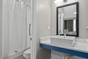 uma casa de banho com um lavatório, um WC e um espelho. em Inn On Arsenal em Watertown