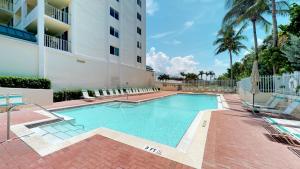 a swimming pool in front of a building at Beachfront at the Apollo Where the Famous Sunsets Never Get Old! in Marco Island