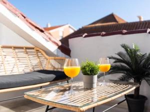 two glasses of orange juice on a table on a balcony at Ático Puerto Fuengirola in Fuengirola