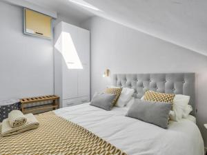 Habitación blanca con cama grande con almohadas en Ático Puerto Fuengirola, en Fuengirola