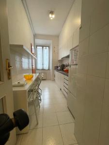 a white kitchen with a counter and a table at Moshi Moshi in Rome