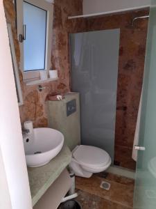a bathroom with a sink and a toilet and a mirror at Sol Pedra Villas in Skala Marion +74 photos
