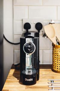 a black juicer sitting on a wooden counter at 2 Bedroom Apartment right on Trafalgar Square in London