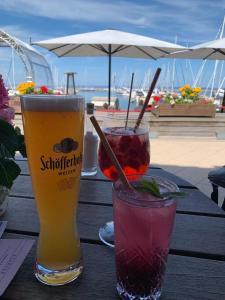 zwei Getränke sitzen auf einem Holztisch in der Unterkunft Ferienwohnung Yachthafenperle in Kühlungsborn