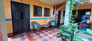 a room with two chairs and a red tile floor at Hospedaje El Viajero in Panajachel