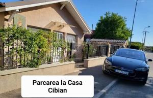 Czarny samochód zaparkowany przed domem w obiekcie Casa Cibian w Braszowie