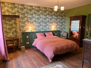 a bedroom with a bed with a pink comforter at Le Clos Chalmon Chambre d'hôte in Montignac