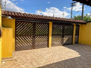 a garage with a large wooden garage door at Casa com Amplo Quintal, Netflix, 5 minutos de carro da Praia in Peruíbe