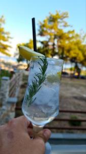 a person holding a glass of water with a drink at Hatzoudis Luxury Suites in Chrysi Ammoudia