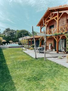 un gran edificio de madera con patio y patio en La Cabane du Ferret, en Lège-Cap-Ferret