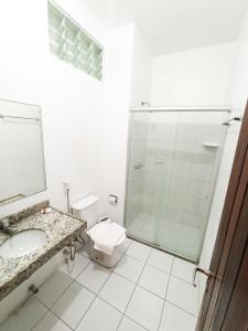 een badkamer met een douche, een wastafel en een toilet bij Algas Praia Hotel in Fortaleza