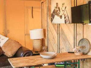 ein Wohnzimmer mit einem Tisch und zwei Giraffen an der Wand in der Unterkunft Semira Tent Lodge in Totnes