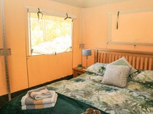 a bedroom with a bed with a window and a window at Semira Tent Lodge in Totnes