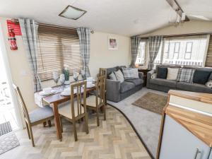 uma sala de estar com uma mesa e um sofá em Poppy Lodge em Stratford-upon-Avon