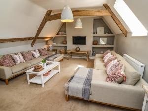 a living room with two couches and a tv at The Compton Cottage in Cheltenham