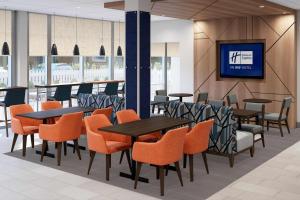 a restaurant with tables and chairs and a tv on a wall at Holiday Inn Express & Suites - Hollister by IHG in Hollister +62 photos