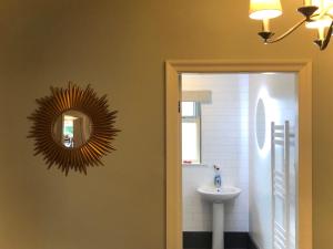 een badkamer met een spiegel en een wastafel bij White Gable in Scarborough +14 foto's